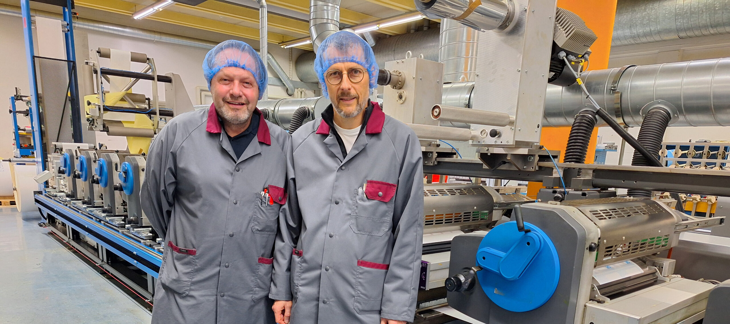 Salvador Hartmann, jefe de producción y Roger Wick, director de operaciones de etiquetas y envases flexibles, con una de las tres prensas mejoradas.